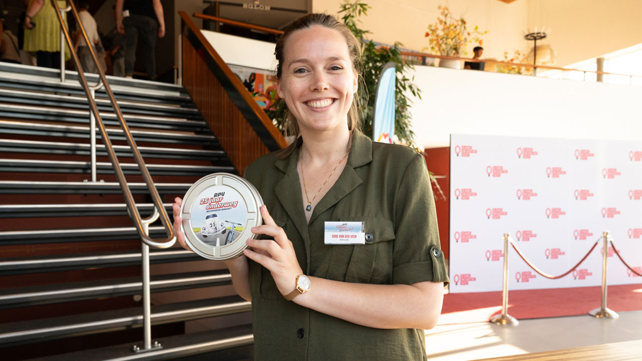 Ambassadeur Geke van TeamAlert poserend met een rond blik met daarop RPV 25 jaar onderweg